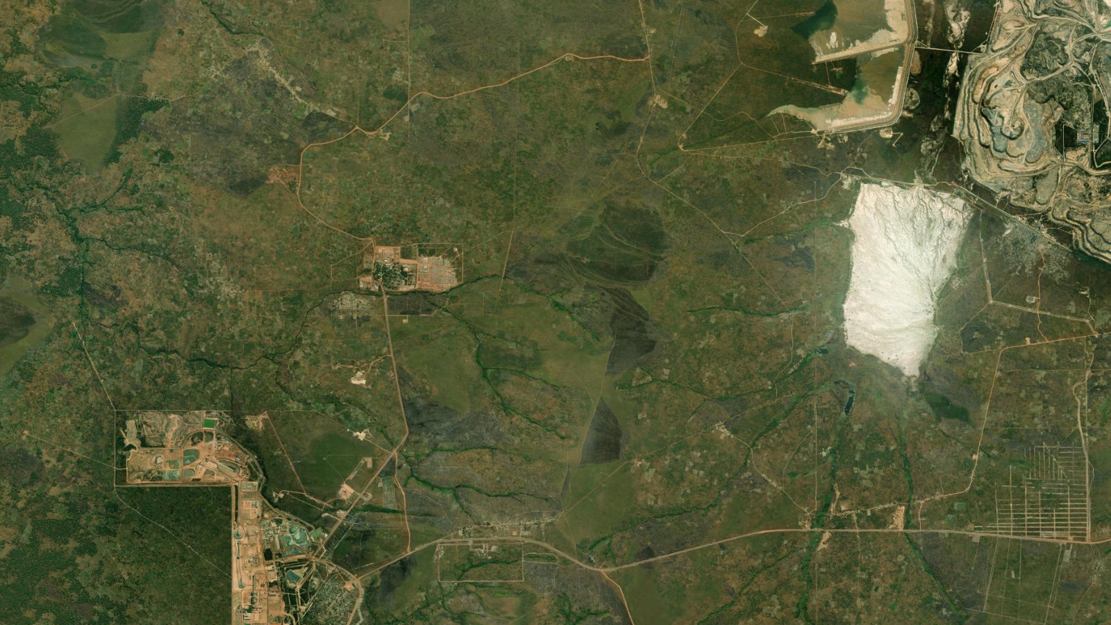 Satellite view of the Kolwezi copper-cobalt district in Lualaba, DRC, showing processing plants, tailings ponds and open pits carved into the surrounding bush.
