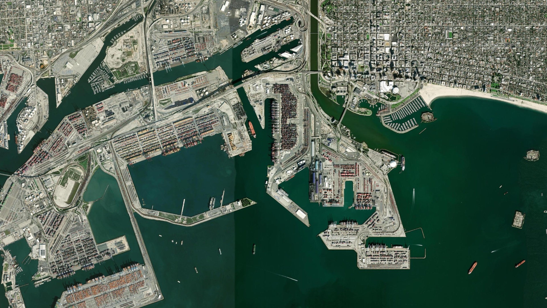 Satellite view of the container terminals at the Port of Long Beach, California, with vessels at berth and stacked container yards.